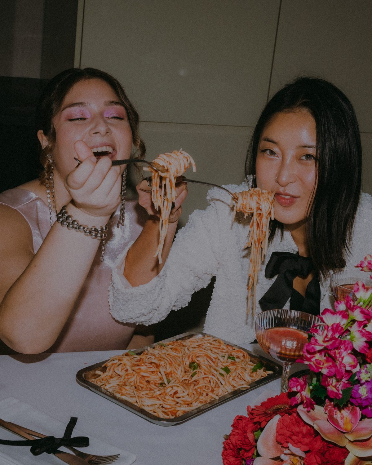 Two friends sharing spaghetti at dinner