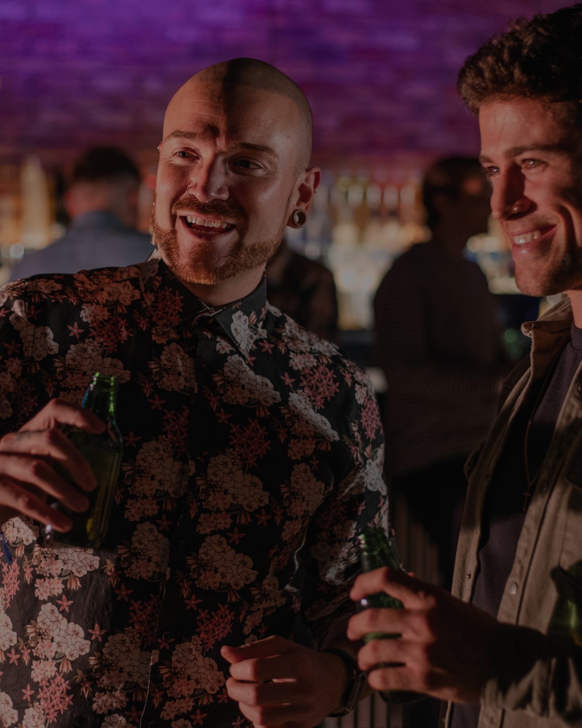 Two friends laughing at a bar